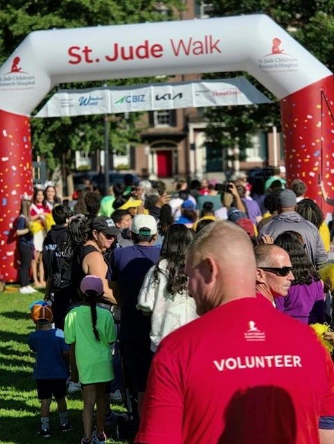 Clancy Brothers team member walking under the St. Jude inflatable arch