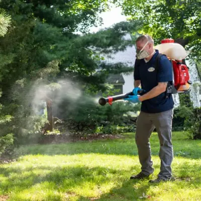 technician spraying for ticks and mosquitoes