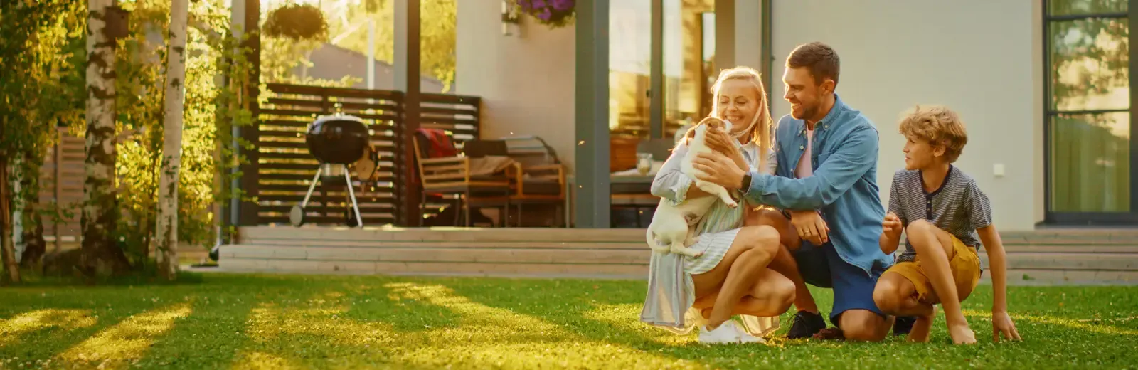 father and kids playing with dog outside