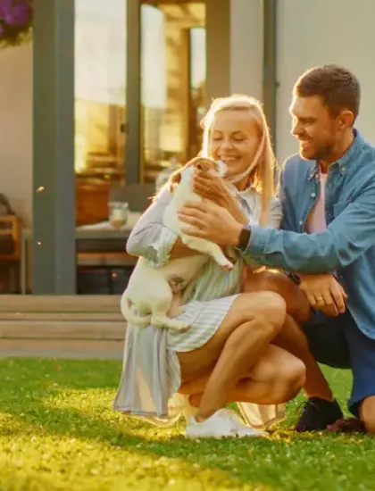 father and daughter playing with dog outside